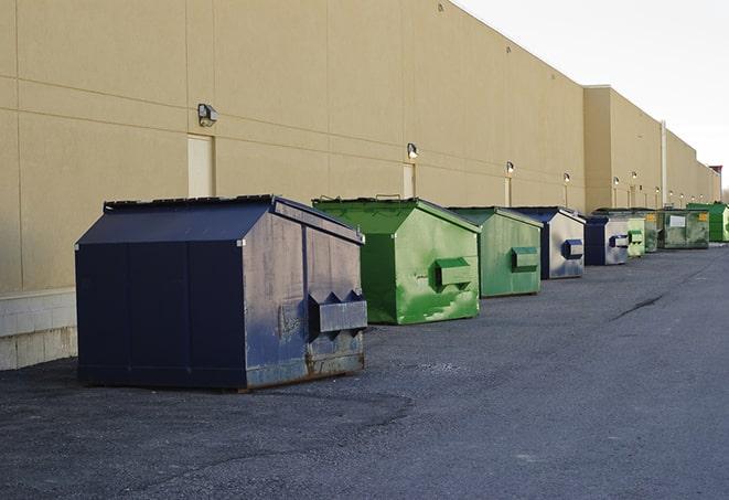 construction workers toss wood scraps into a dumpster in Lakebay